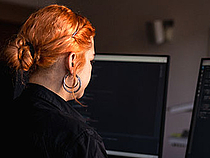 Bachelor IT-Sicherheit Eine rothaarige Studentin am PC.